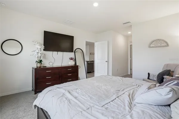 a bedroom with a bed a lamp and a flat screen tv