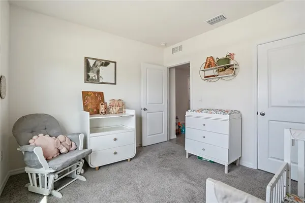 a room with a baby bed and dresser