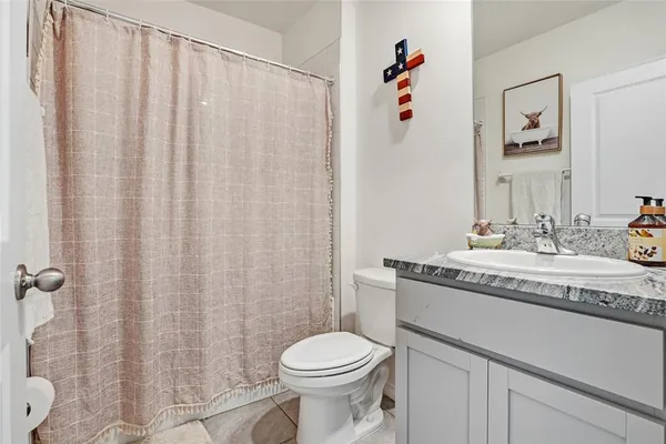 a bathroom with a granite countertop sink a toilet and a mirror