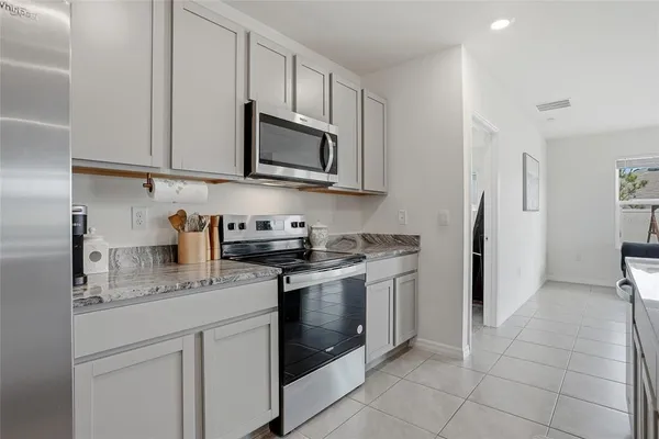 a kitchen with stainless steel appliances granite countertop a stove a microwave and a refrigerator
