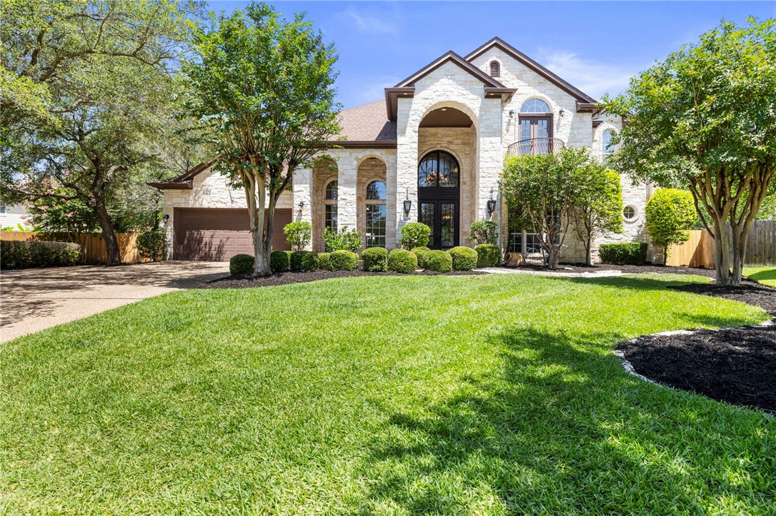 a view of house with garden and tall trees