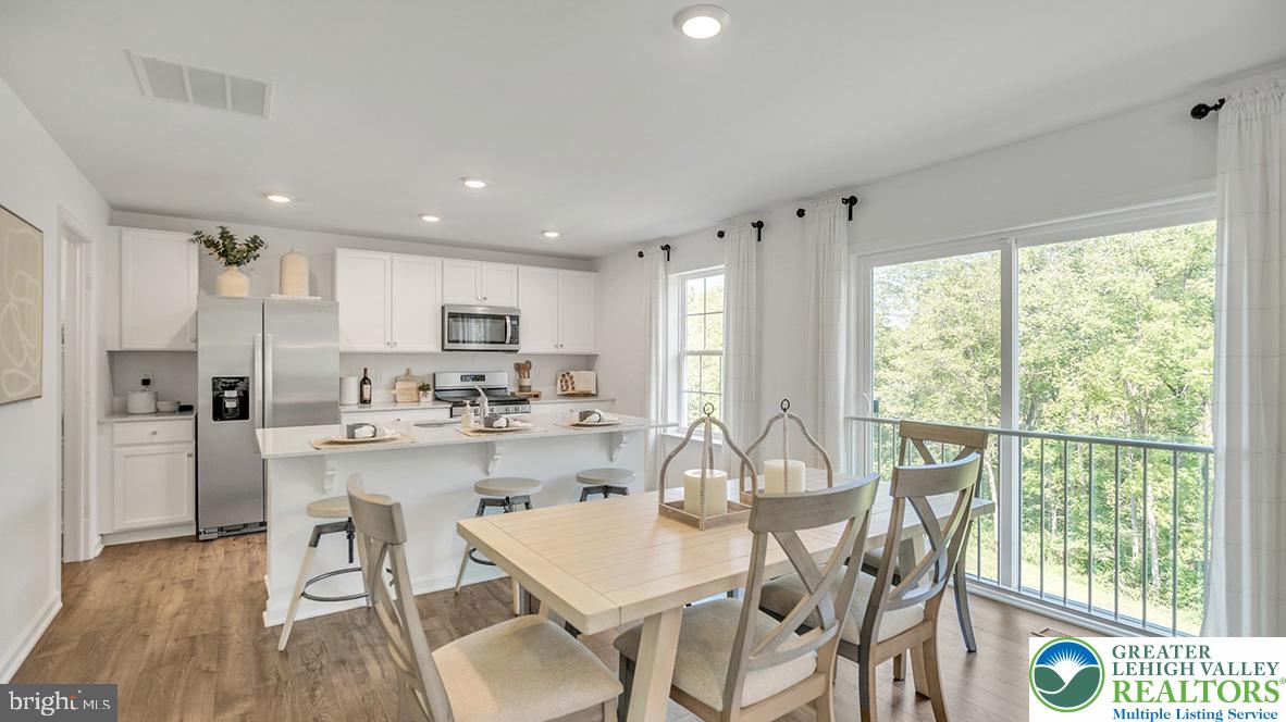 115 Winding Road Easton, PA 18040 - Photo 8 of 24 This open-concept kitchen and dining area features abundant natural light, offering seamless indoor-outdoor living.