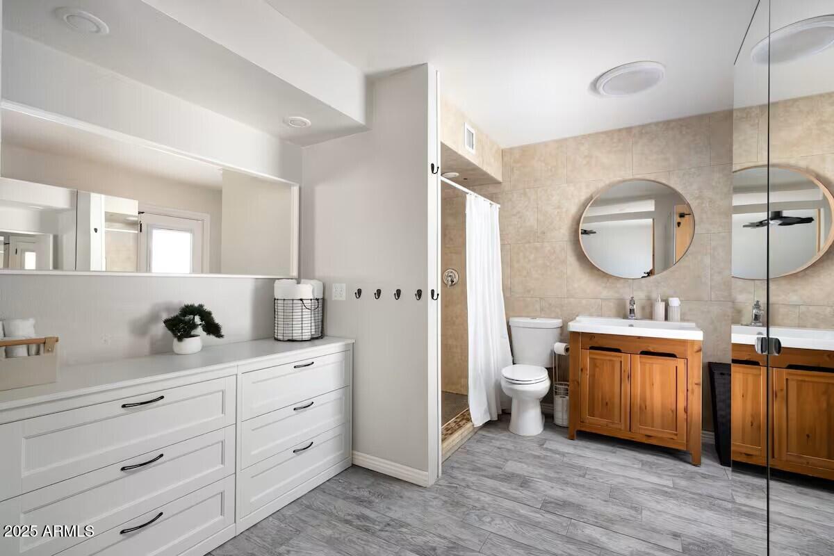 922 West Monte Avenue Mesa, AZ 85210 - Photo 30 of 41 a bathroom with a double vanity sink a toilet and a mirror