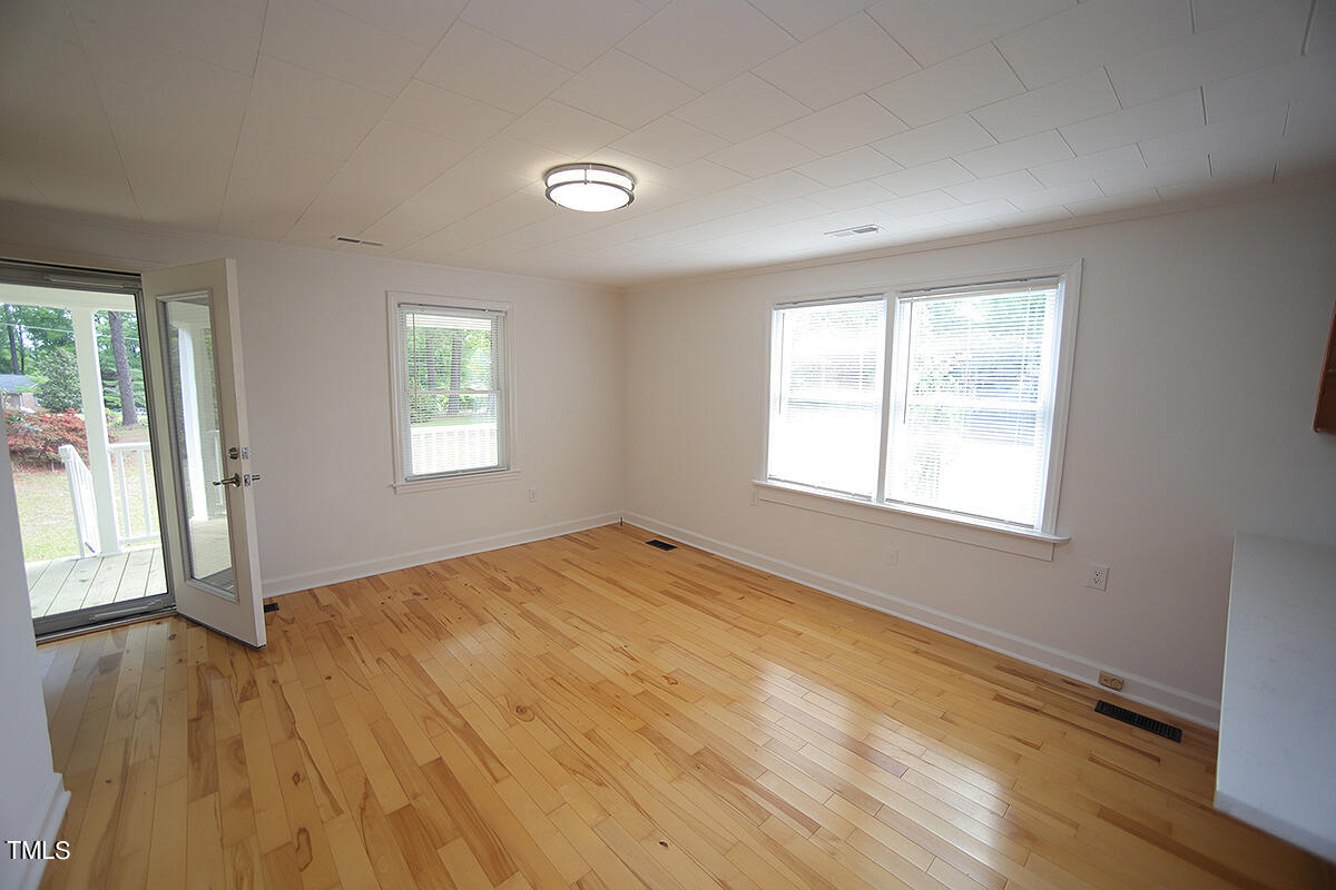 305 West Watson Road Benson, NC 27504 - Photo 12 of 30 a view of an empty room with wooden floor and a window