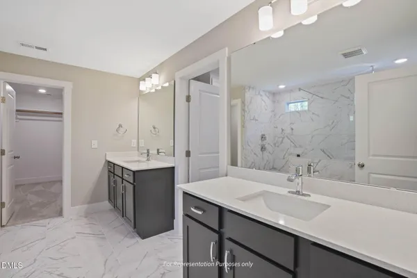 a bathroom with a granite countertop sink a toilet a large mirror and shower