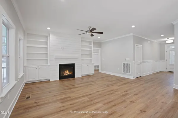 a view of a livingroom with a fireplace a ceiling fan and window