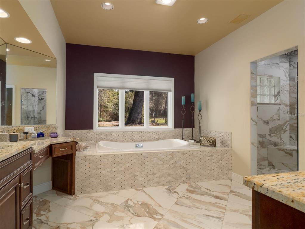 4986 Southwest 7th Avenue Road Ocala, FL 34471 - Photo 14 of 39 a spacious bathroom with a granite countertop tub sink and mirror