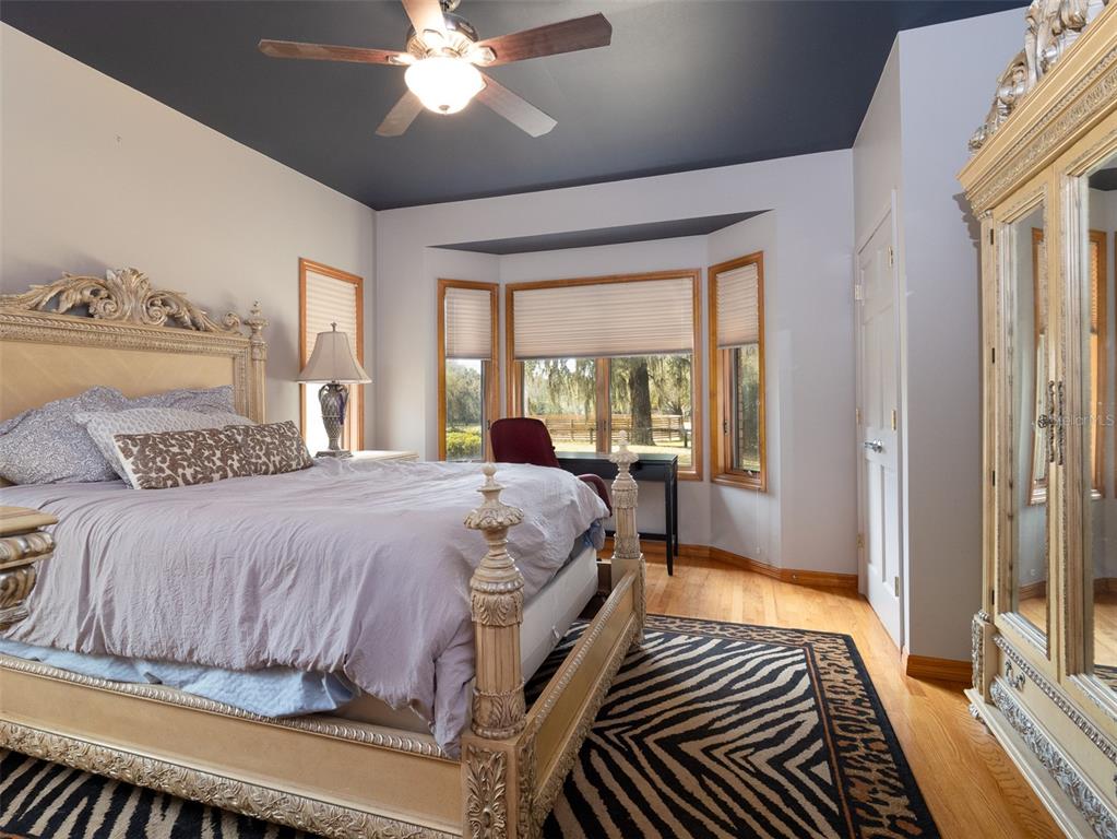 4986 Southwest 7th Avenue Road Ocala, FL 34471 - Photo 17 of 39 a bedroom with a large bed and a chandelier