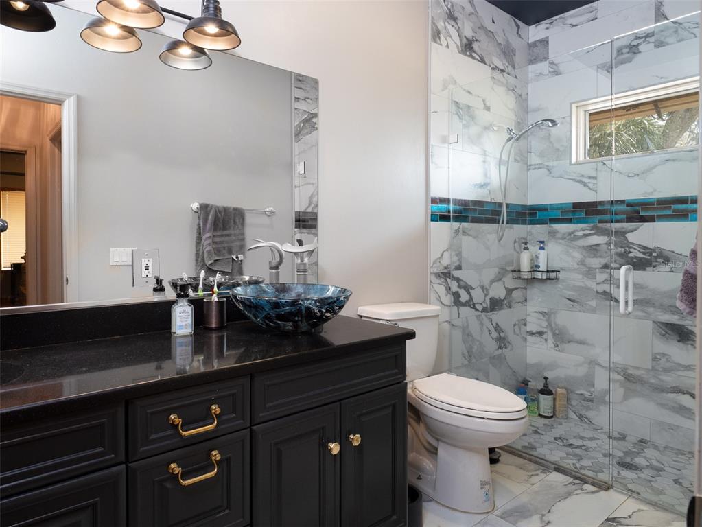 4986 Southwest 7th Avenue Road Ocala, FL 34471 - Photo 18 of 39 a bathroom with a granite countertop toilet sink and mirror