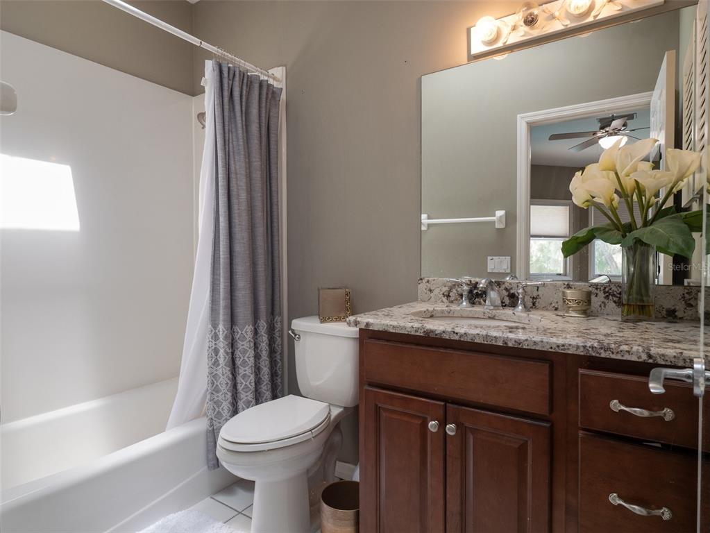 4986 Southwest 7th Avenue Road Ocala, FL 34471 - Photo 23 of 39 a bathroom with a granite countertop sink toilet and shower