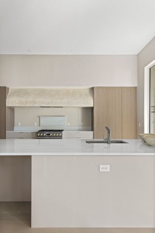 a dining hall with stainless steel appliances kitchen island granite countertop a refrigerator a sink dishwasher a dining table and chairs with wooden floor