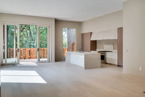 a kitchen with stainless steel appliances a white stove top oven and white cabinets