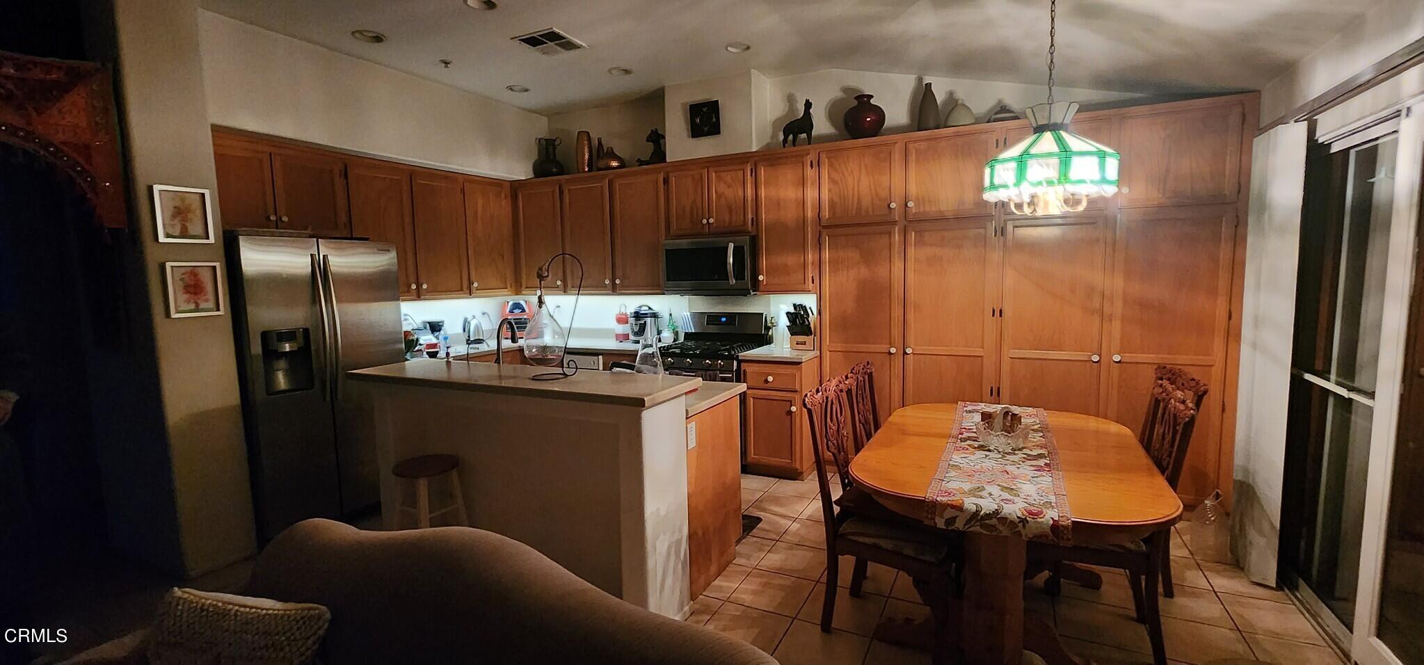 1500 Gabriella Drive Oxnard, CA 93030 - Photo 10 of 23 a kitchen with stainless steel appliances a refrigerator a stove a sink a dining table and chairs