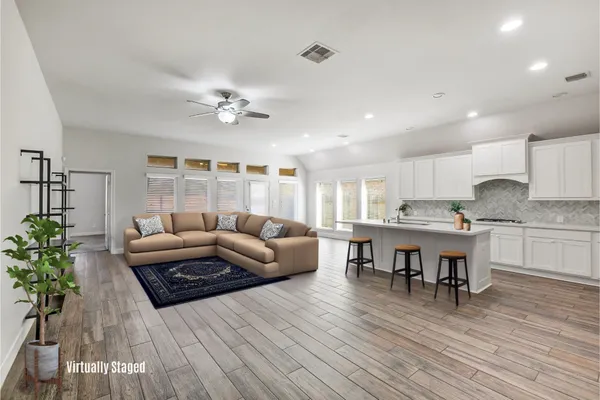 a living room with furniture and a wooden floor