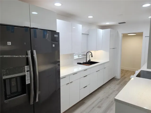 a kitchen with stainless steel appliances a refrigerator sink and microwave