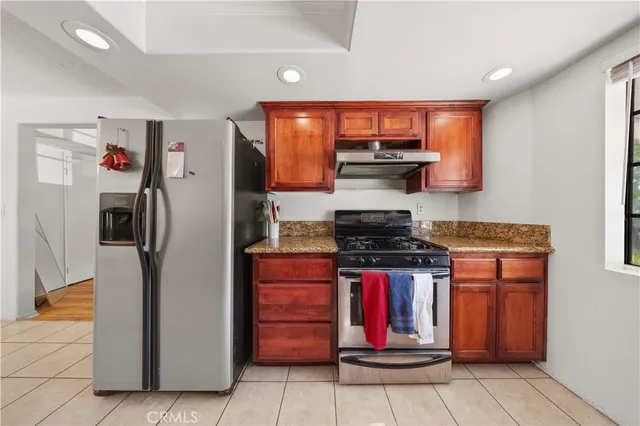 a kitchen with stainless steel appliances granite countertop a stove and a refrigerator