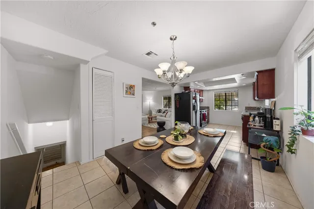 a view of a dining room with furniture a chandelier and wooden floor