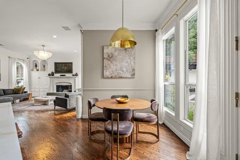 a dining room with furniture wooden floor a fireplace and a chandelier