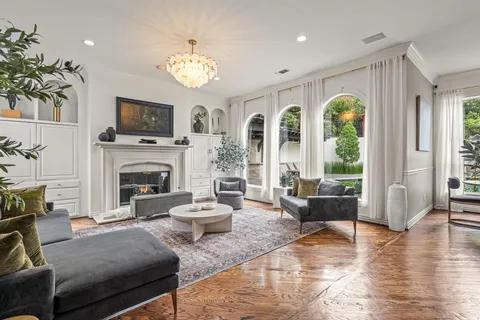 a living room with furniture a fireplace a flat screen tv and a large window