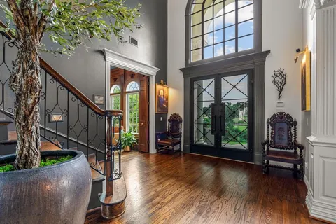 a view of front door with hallway and wooden floor