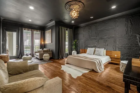 a spacious bedroom with a bed couch and a large window