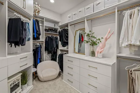 a view of walk in closet with clothes and shoes