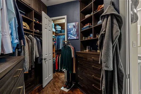 a view of walk in closet with clothes and shoes