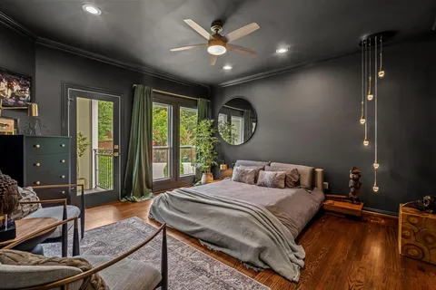 a bedroom with a bed a chandelier and a large window