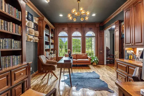 a living room with furniture a bookshelf and a large window