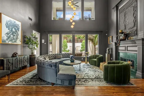 a living room with fireplace furniture and a large window
