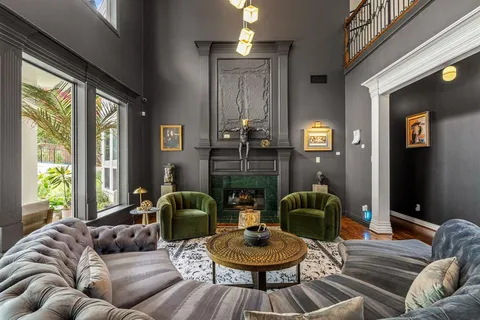 a living room with fireplace furniture and a large window