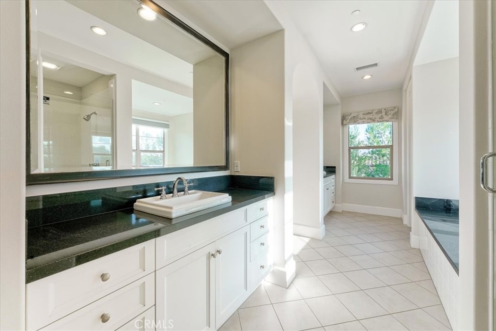 72 Clifford Irvine, CA 92618 - Photo 43 of 65 a bathroom with a double vanity sink a mirror and a bathtub