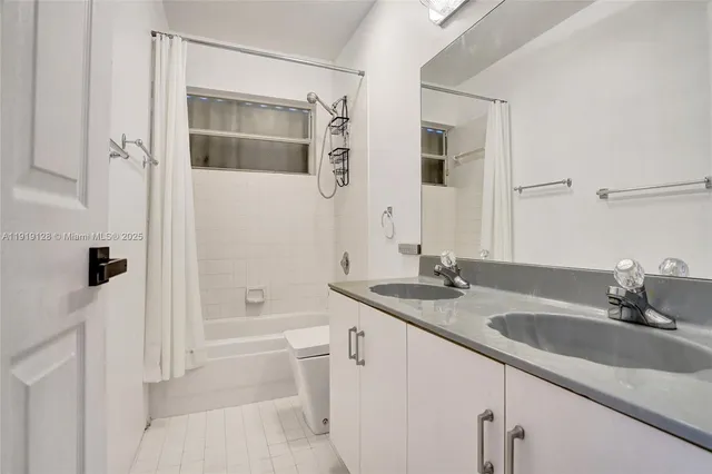 a bathroom with a granite countertop sink mirror and a bathtub