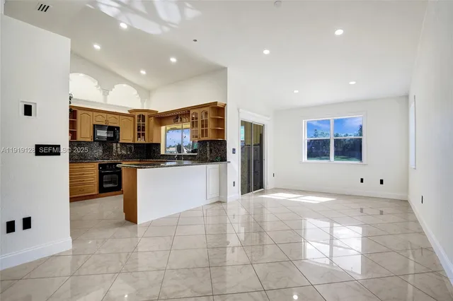 a kitchen with stainless steel appliances kitchen island granite countertop a refrigerator and a stove top oven