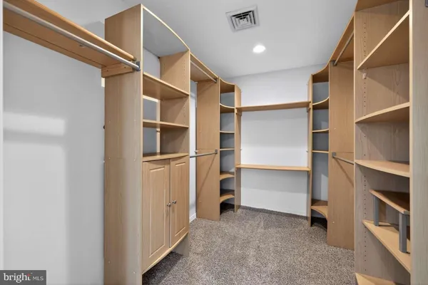 a view of walk in closet with empty racks
