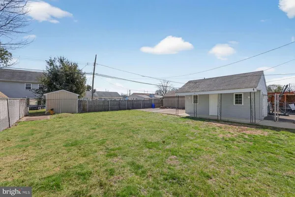 a view of a backyard with table and chairs and wooden fence