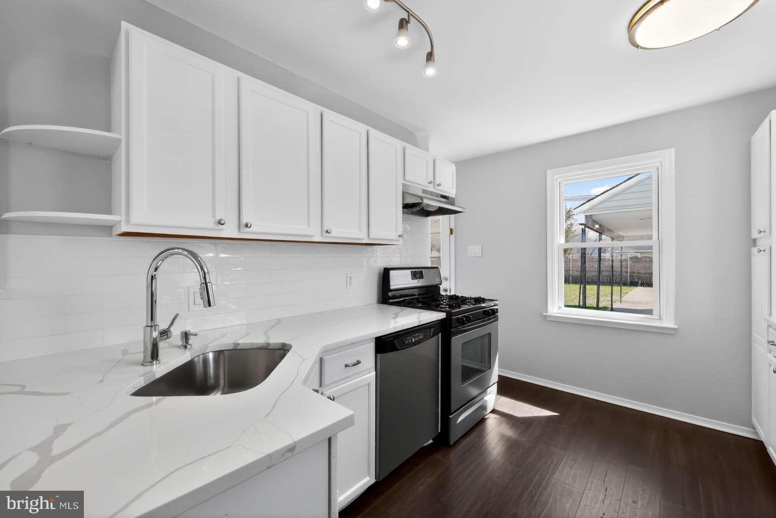 916 Stephen Avenue Croydon, PA 19021 - Photo 9 of 34 a kitchen with stainless steel appliances granite countertop a sink stove and cabinets