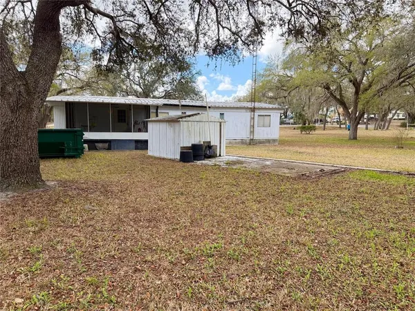 a view of a house with a yard and large tree
