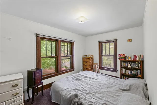 a bedroom with a bed a table and a window