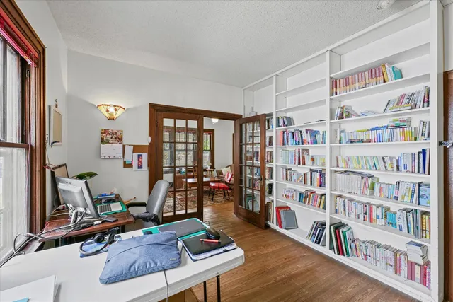 a room with furniture lots of books and a large window