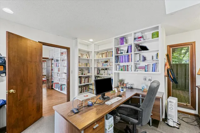 a view of a workspace with furniture and bookshelf