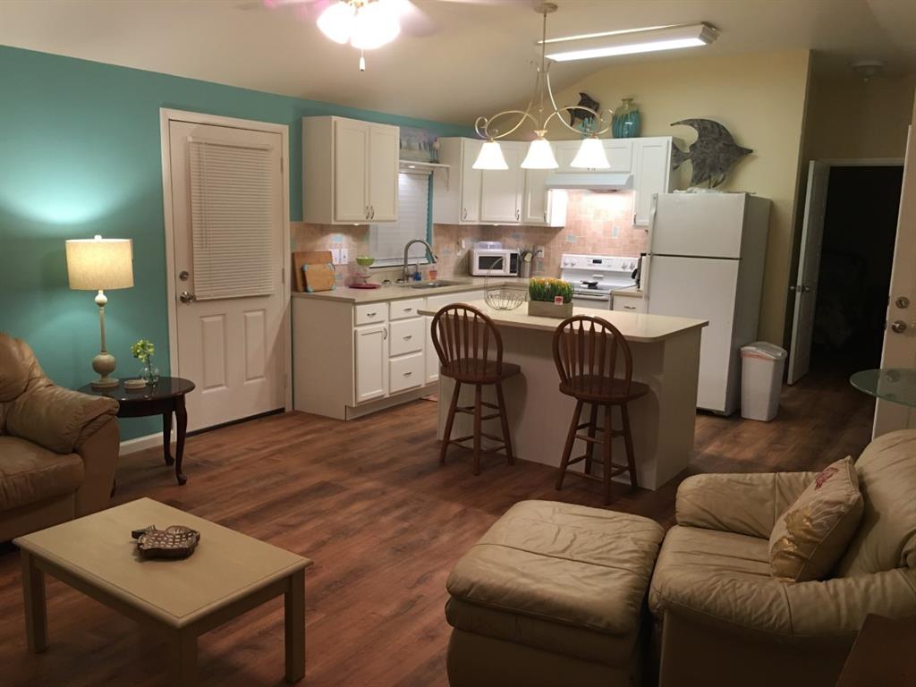 a living room with furniture a refrigerator and kitchen view