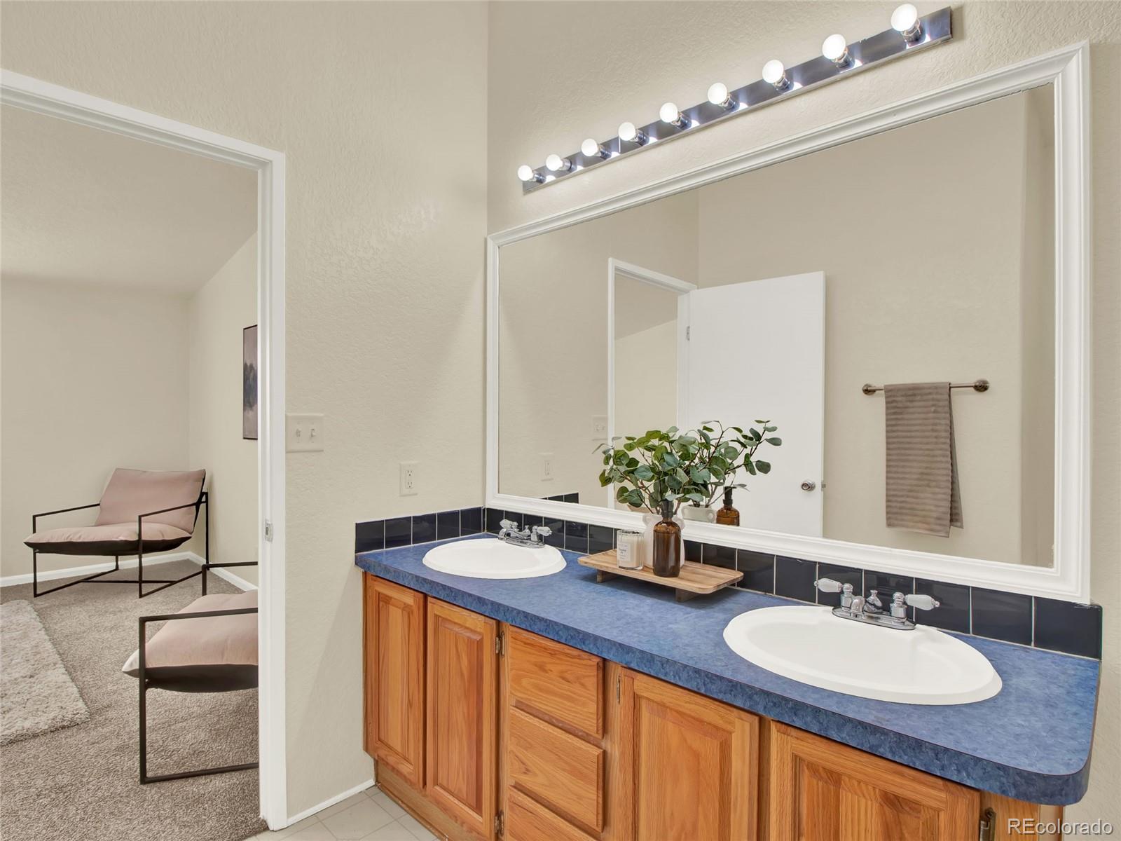 7798 Richard Avenue Fort Lupton, CO 80621 - Photo 23 of 45 a bathroom with a granite countertop sink and a mirror
