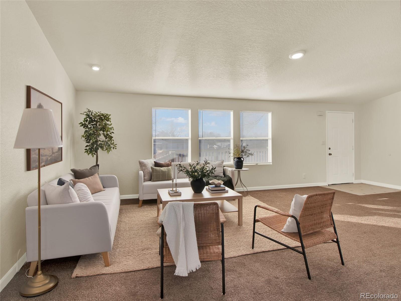 7798 Richard Avenue Fort Lupton, CO 80621 - Photo 9 of 45 a living room with furniture and a large window
