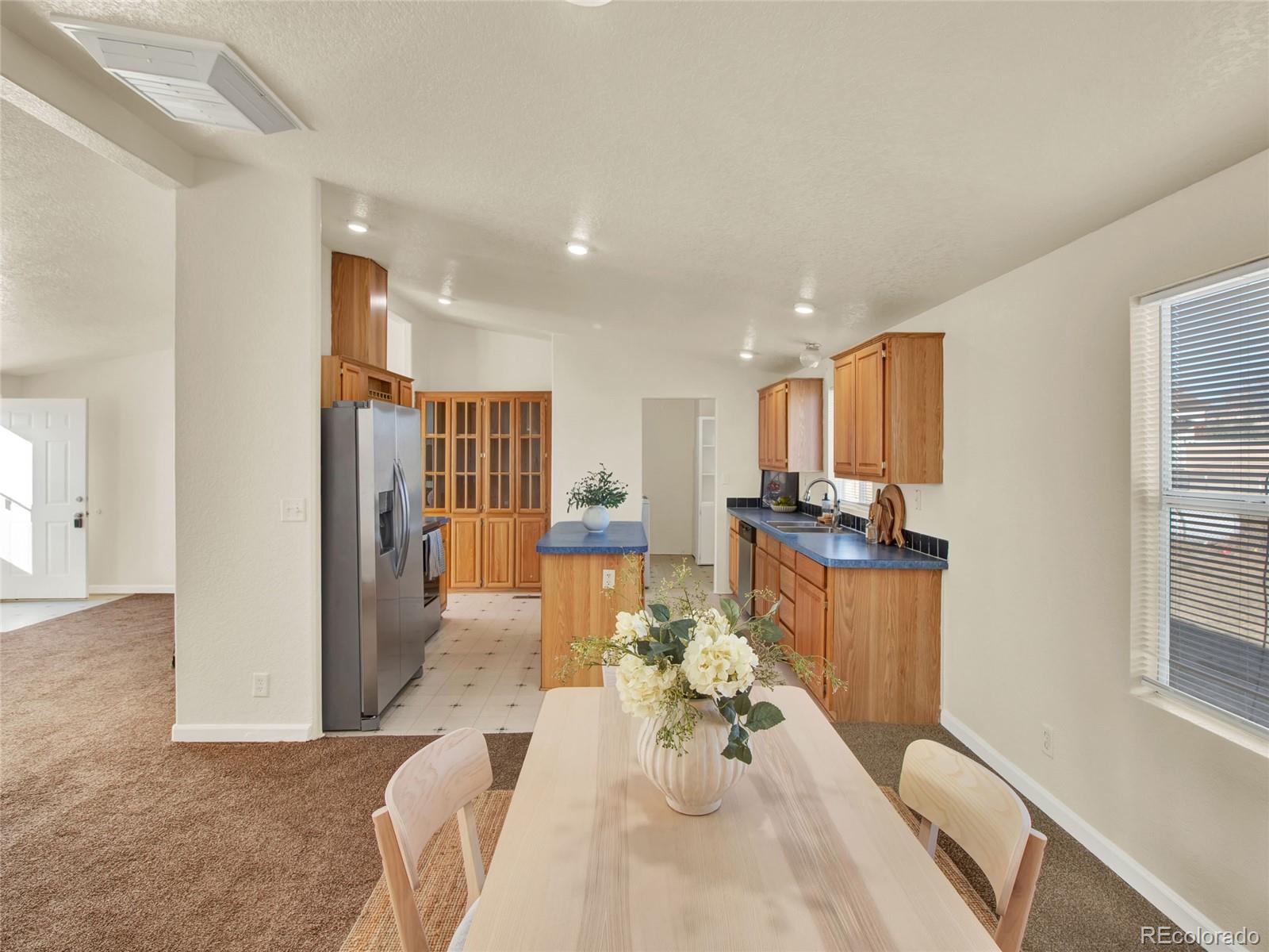 7798 Richard Avenue Fort Lupton, CO 80621 - Photo 10 of 45 a living room with furniture a wooden floor and a chandelier