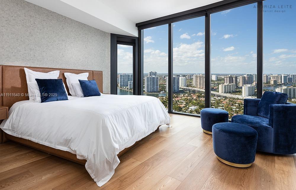 18555 Collins Avenue, Unit 3005 Sunny Isles Beach, FL 33160 - Photo 30 of 57 a large bedroom with a large bed and glass window