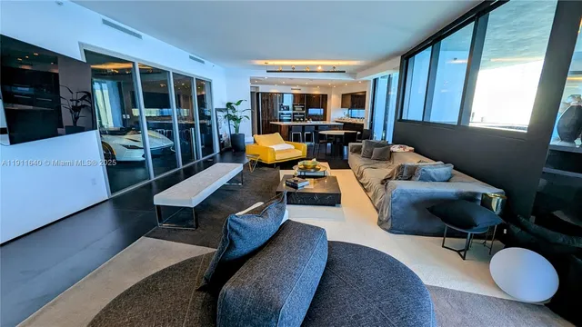 a living room with furniture fireplace and a large window