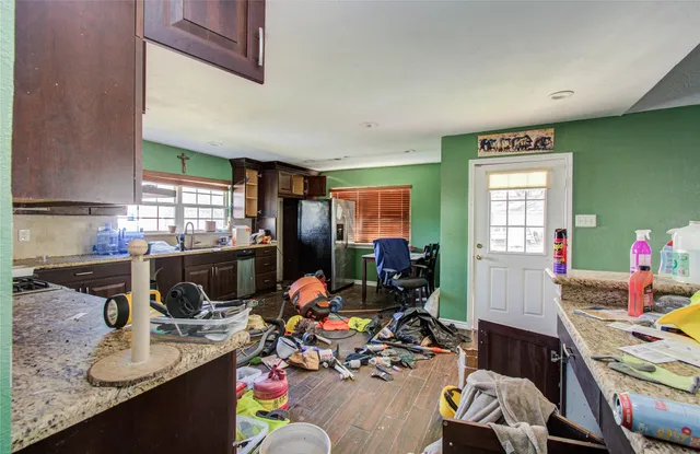 an empty room with wooden floor chandelier fan and windows