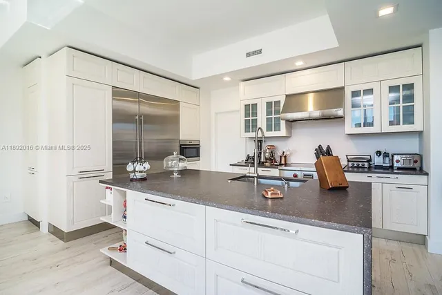 a living room with stainless steel appliances furniture a dining table and kitchen view