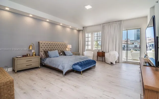 a spacious bedroom with a large bed and a chandelier